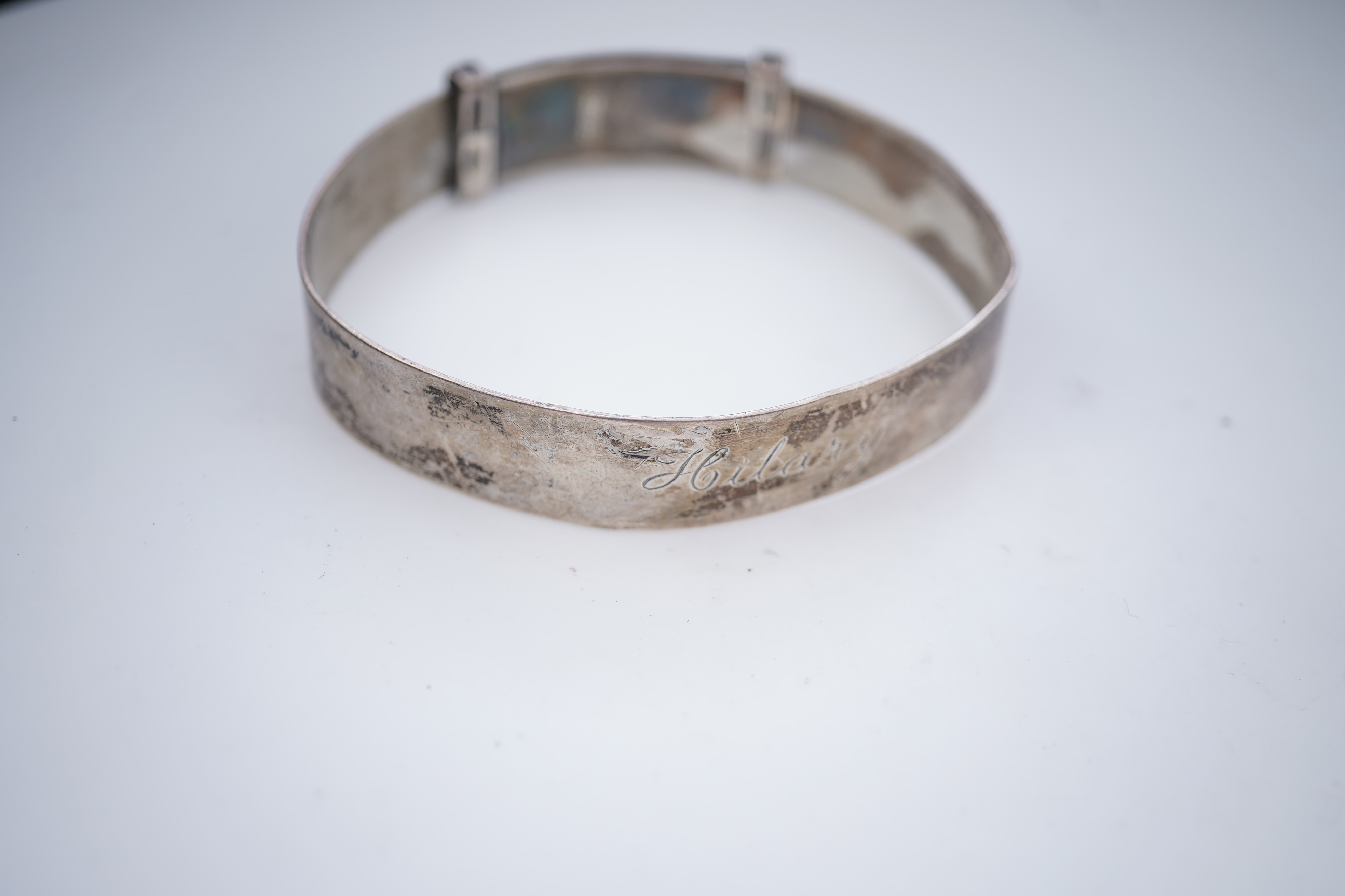 A collection of silver jewels, comprising: a bangle; a chain necklace suspending two winding toothpicks, one with toothpick deficient; a rope twist chain; a pair of cufflinks with the initials DBH; a pendant of abstract